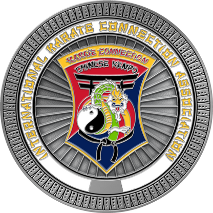 A circular metallic emblem or medallion for International Karate Connection Association Chinese Kenpo, featuring a silver outer ring, a central shield with a red and blue background, a green dragon, a white yin-yang symbol, and yellow lettering.
